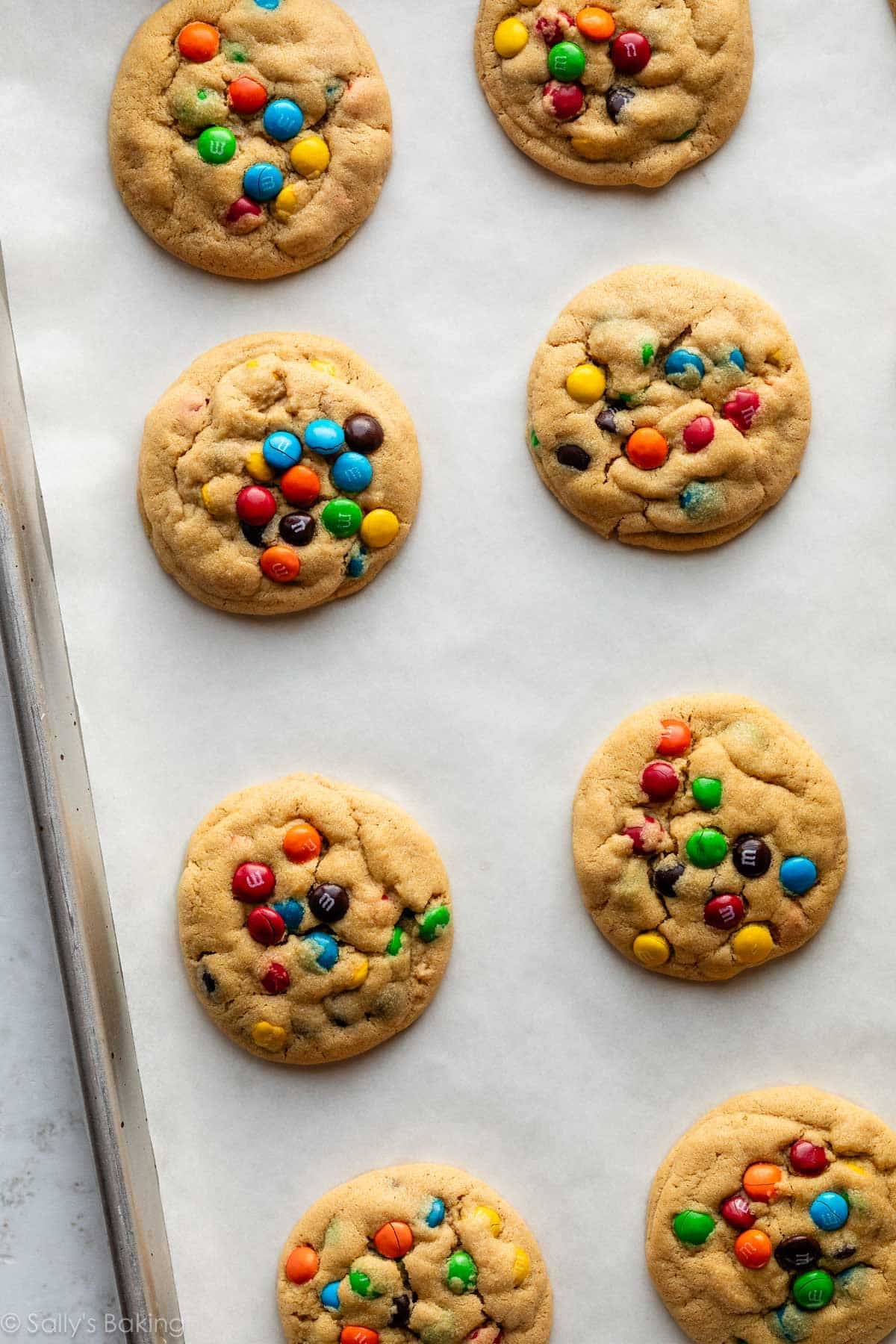 peanut butter M&Ms cookies on lined baking sheet.