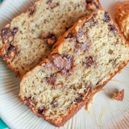 slices of Nutella swirl peanut butter banana bread on a white plate with a spoonful of peanut butter