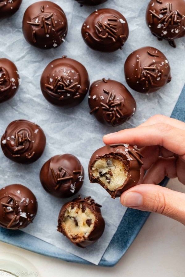 hand holding chocolate chip cookie dough truffle.