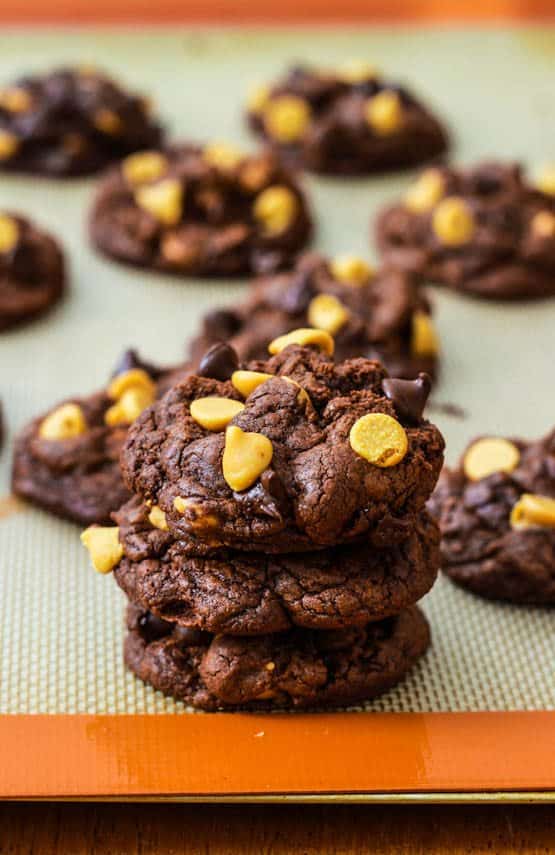 stack of chocolate peanut butter chip cookies on a silpat baking mat