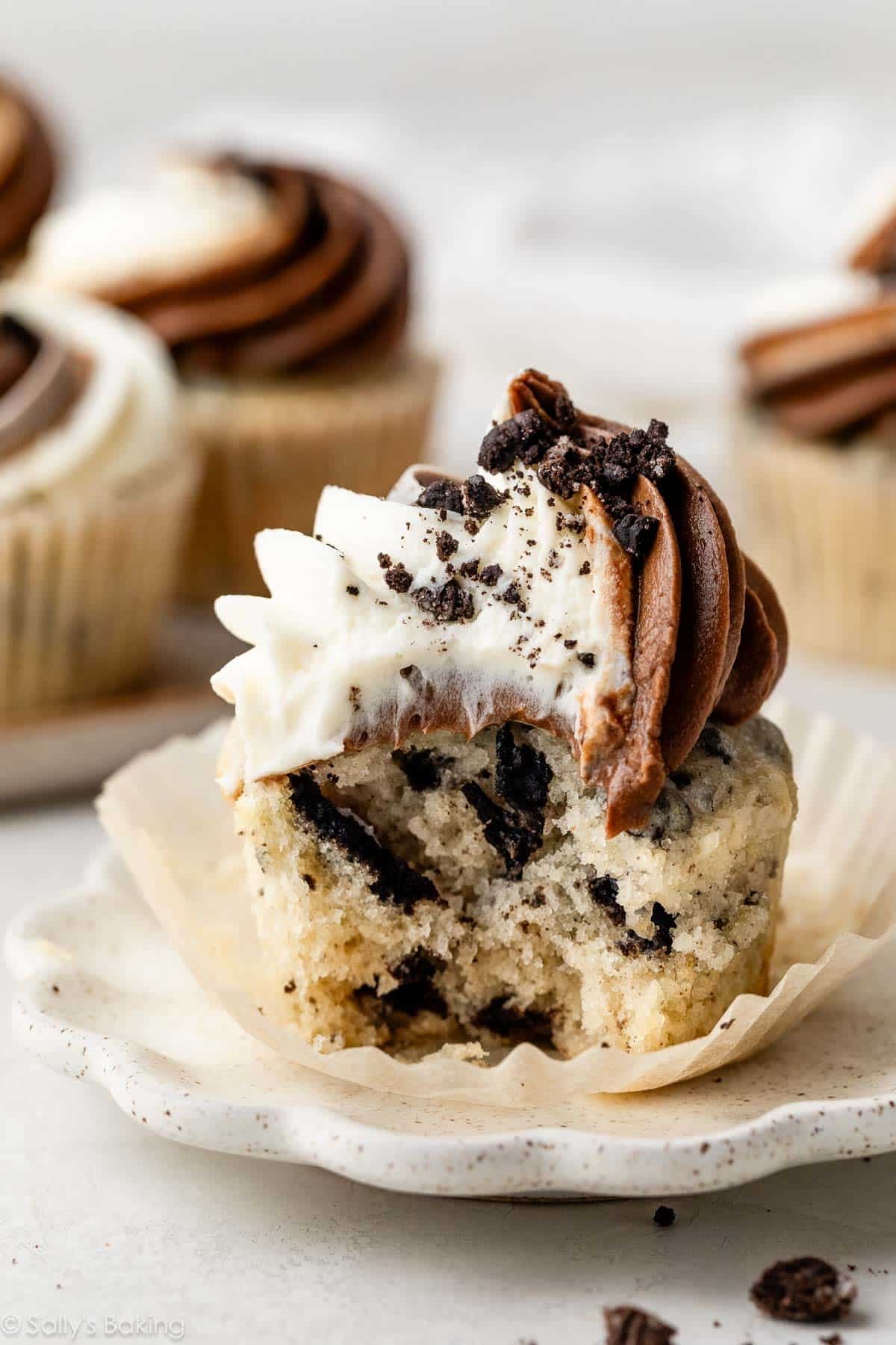 cookies and cream Oreo cupcake with swirled vanilla and chocolate frosting on top.
