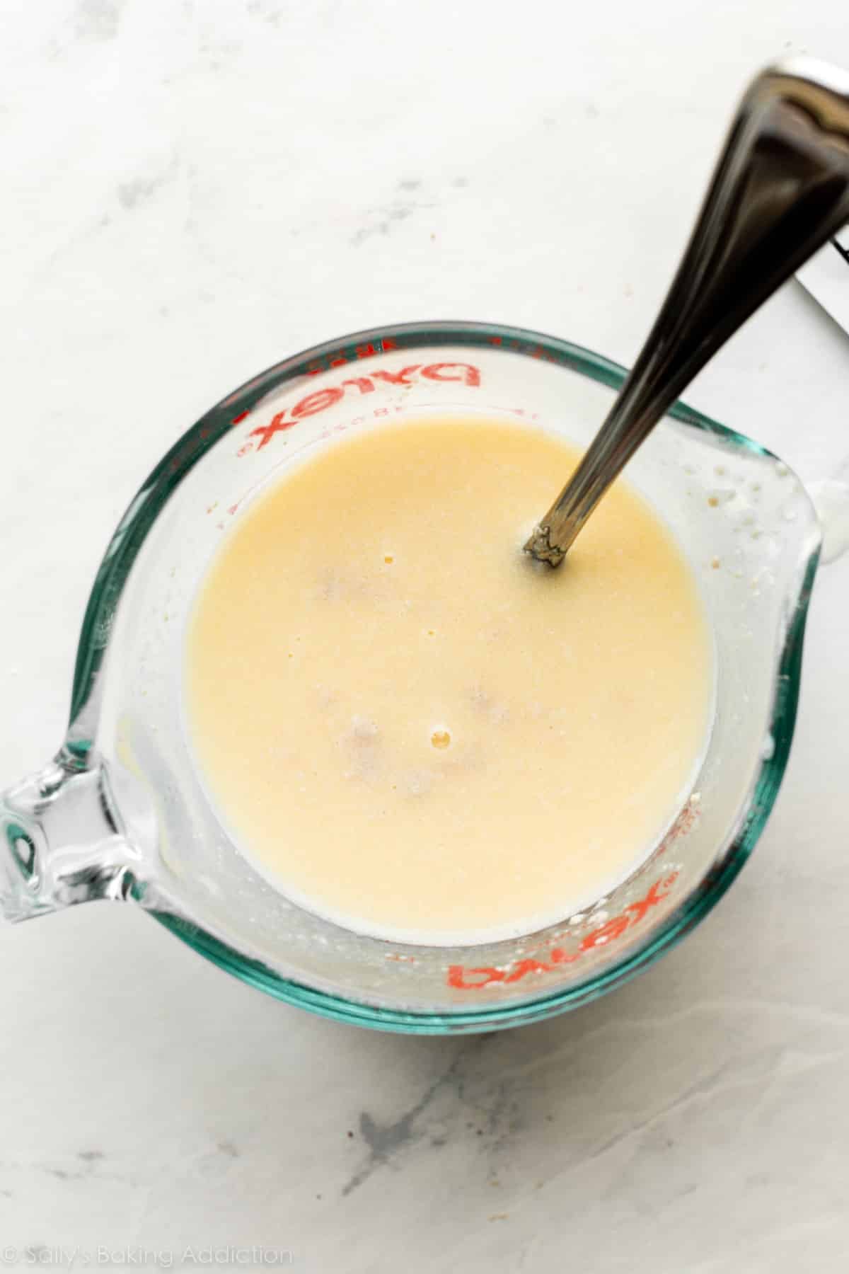 liquid measuring cup full of yellow liquid.