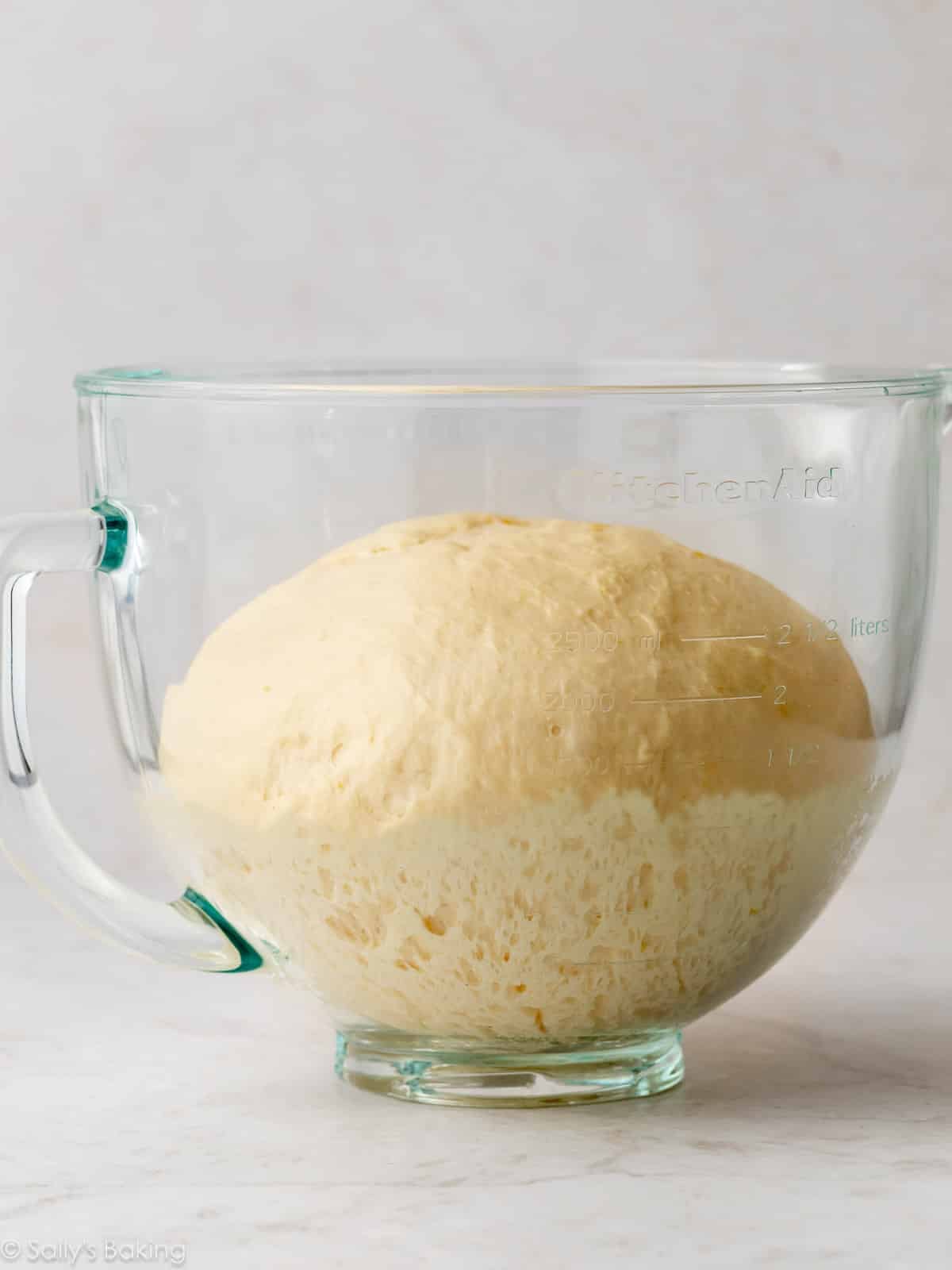 dough risen in glass bowl.