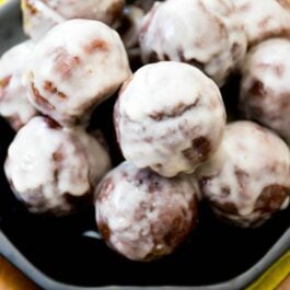 stack of glazed chocolate donut holes on a black plate