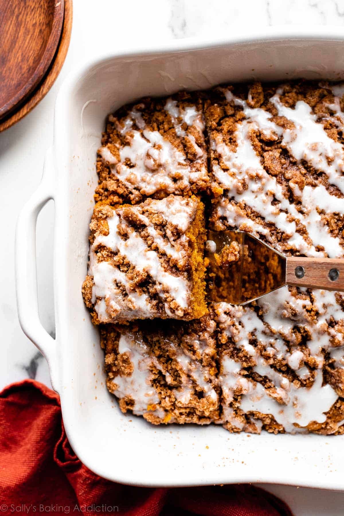 iced pumpkin coffee crumb cake in white baking dish