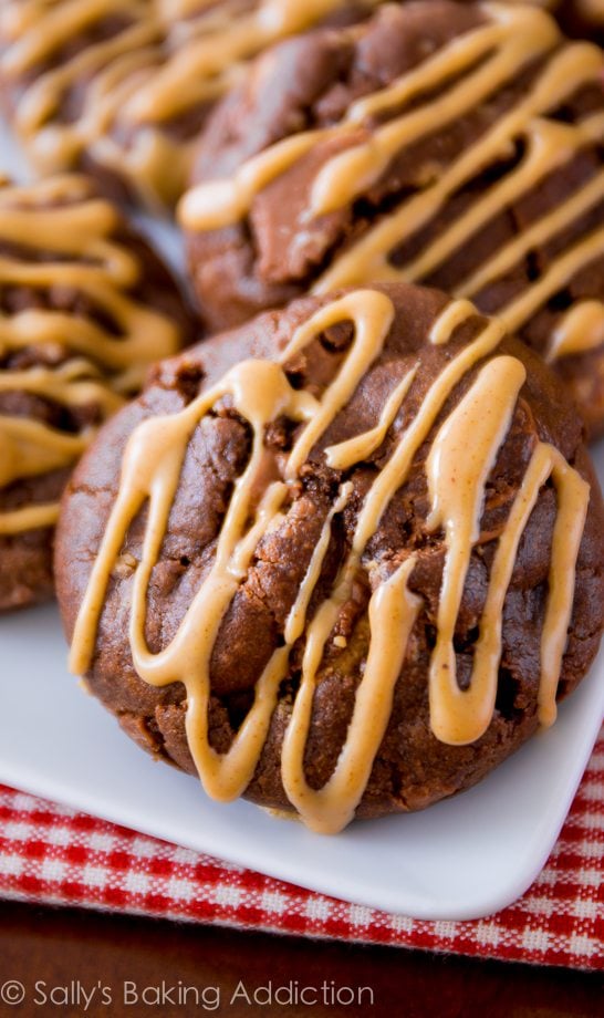 chocolate cookies with peanut butter drizzle on a white plate