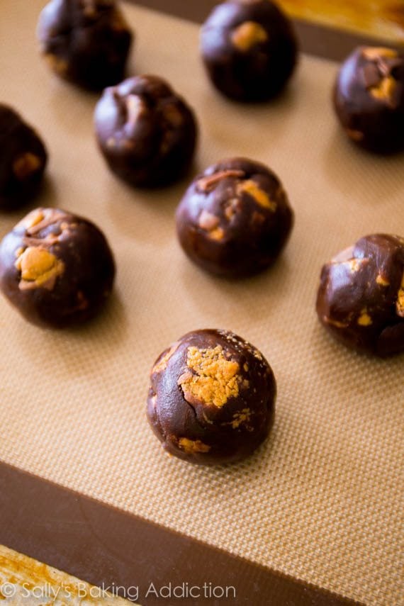 peanut butter chocolate cookie dough balls on a silpat baking mat