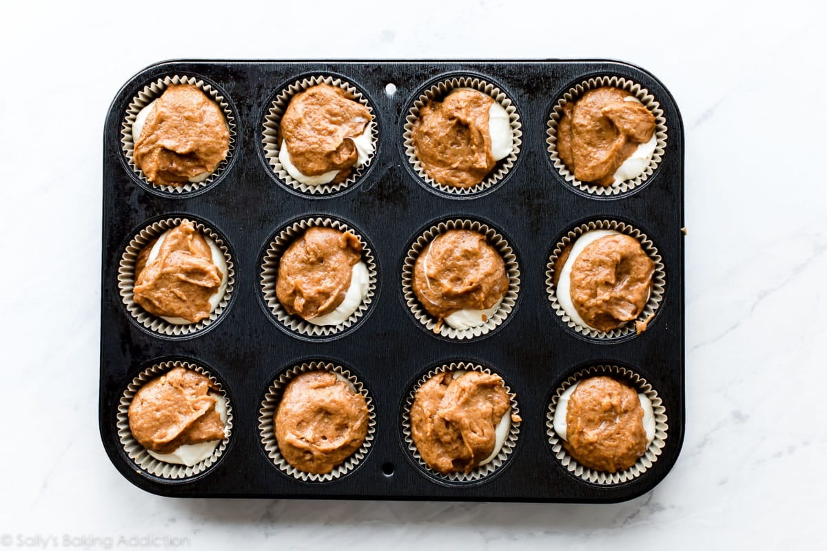 pumpkin cheesecake muffin batter in muffin pan