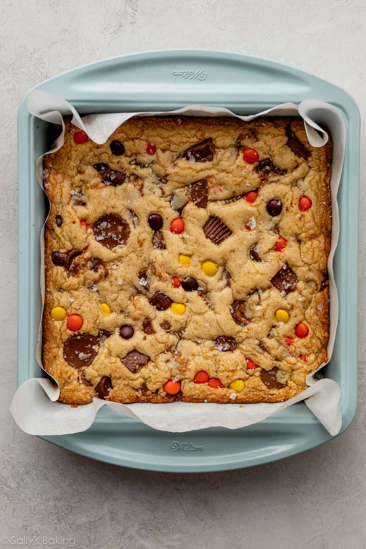 candy bar blondies with sea salt on top in blue pan.