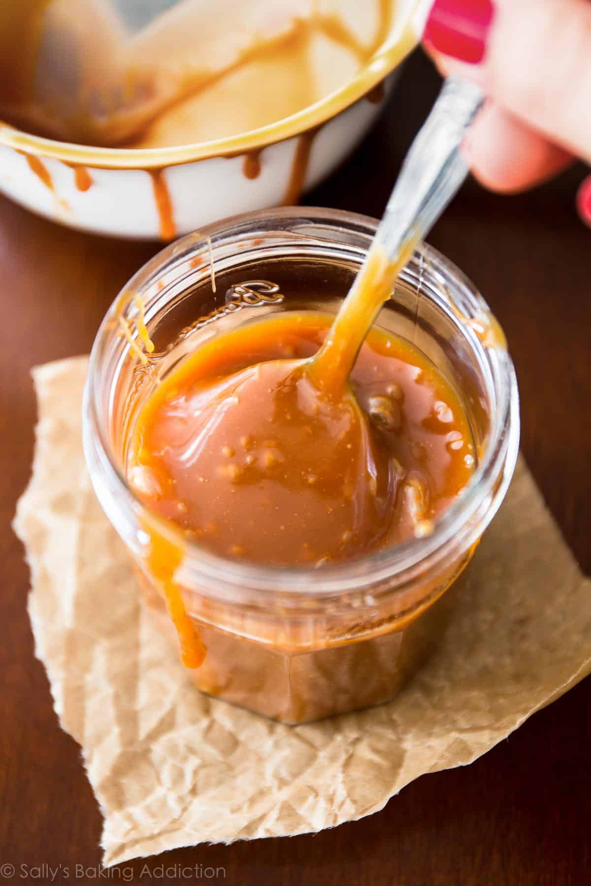 Salted caramel in a glass jar with a spoon