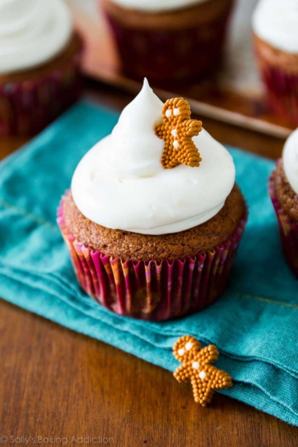 gingerbread cupcakes topped with cream cheese frosting and a decorative gingerbread man candy