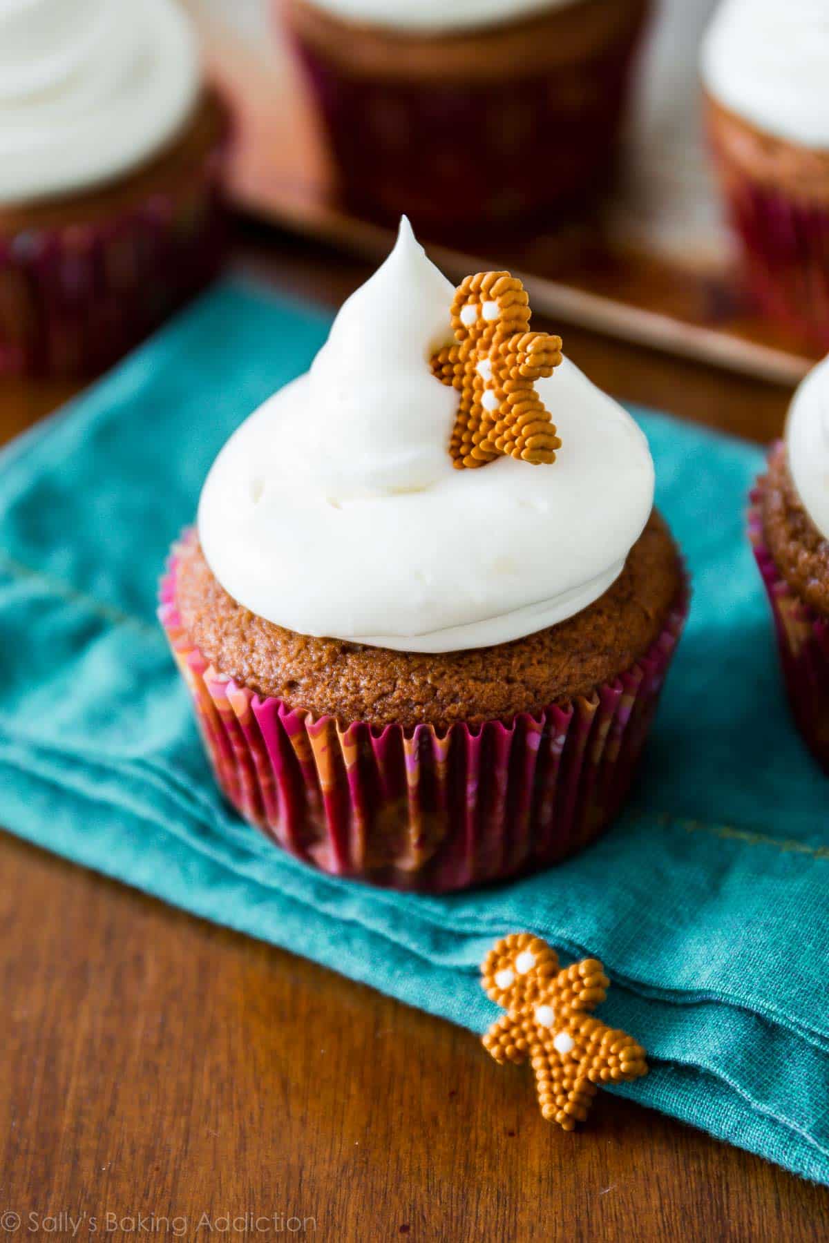 gingerbread cupcakes topped with cream cheese frosting and a decorative gingerbread man candy