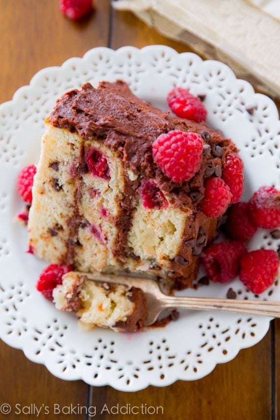 slice of raspberry chocolate chip layer cake on a white plate with a fork