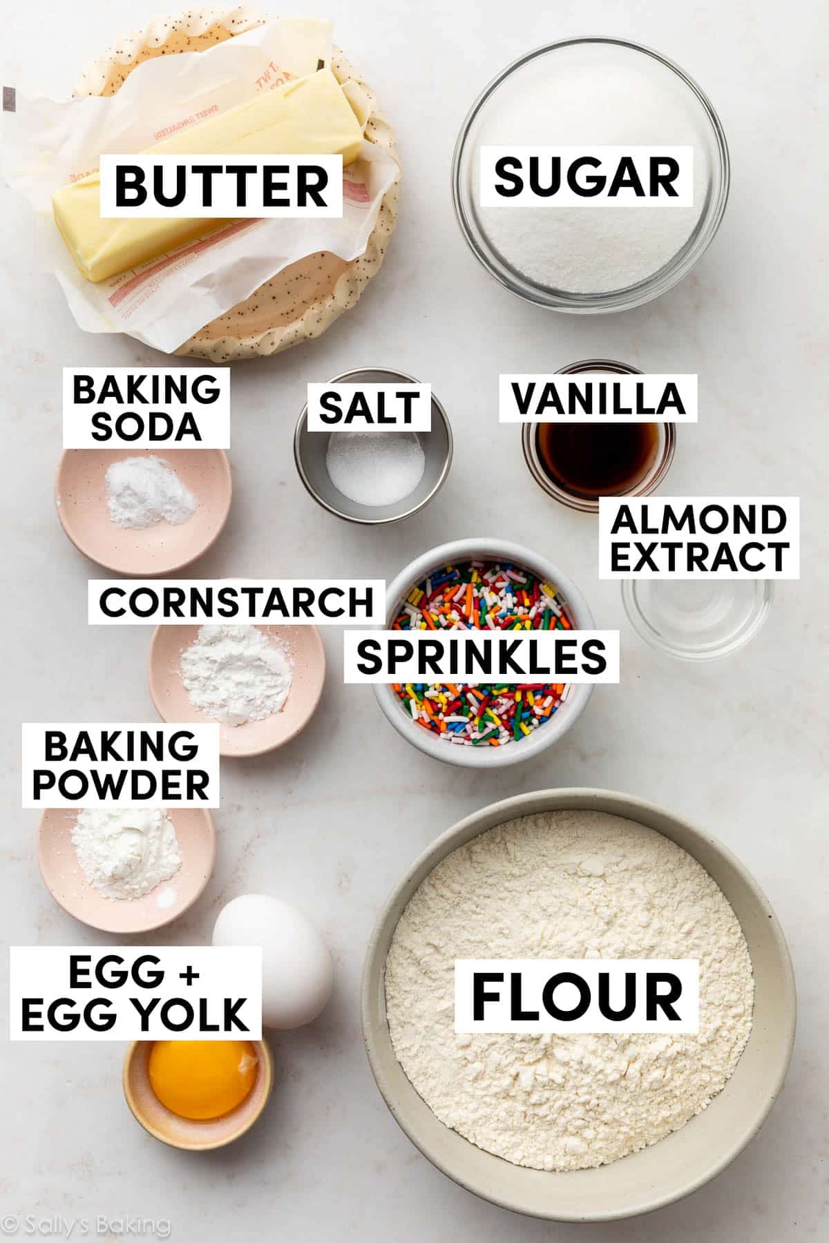 ingredients measured in bowls including sugar, vanilla, sprinkles, flour, baking powder, and butter.