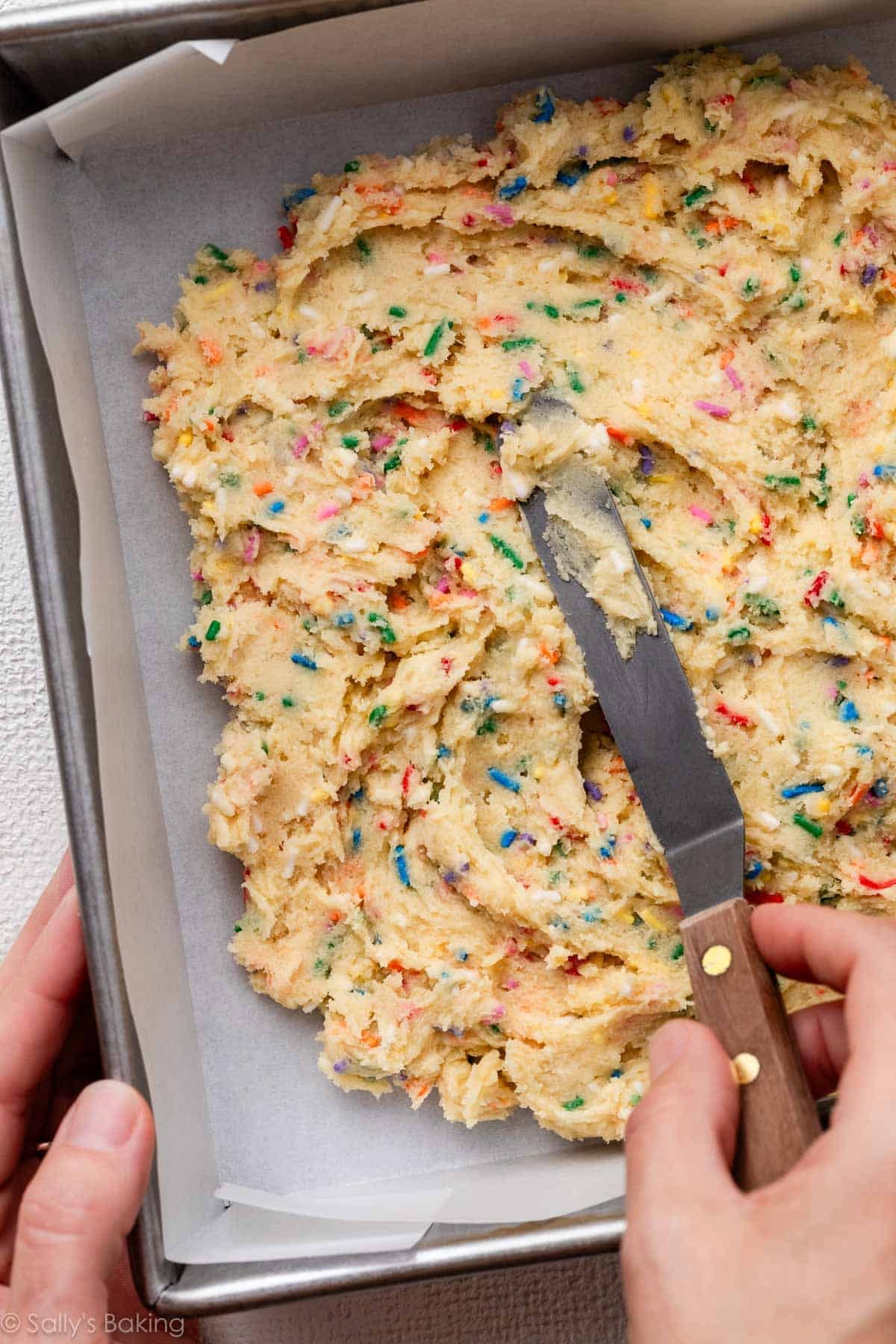 spreading dough into square baking pan.