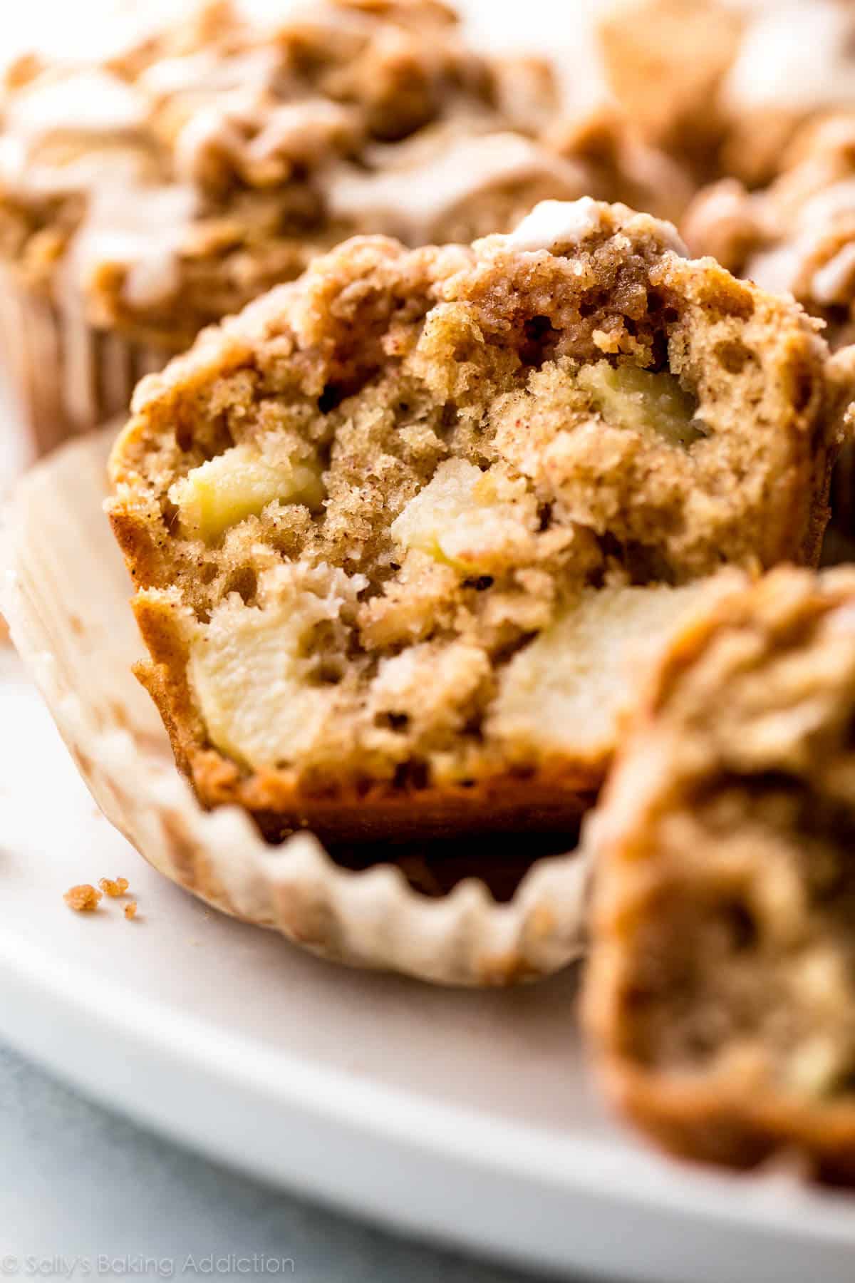 apple cinnamon muffin cut in half on a white plate