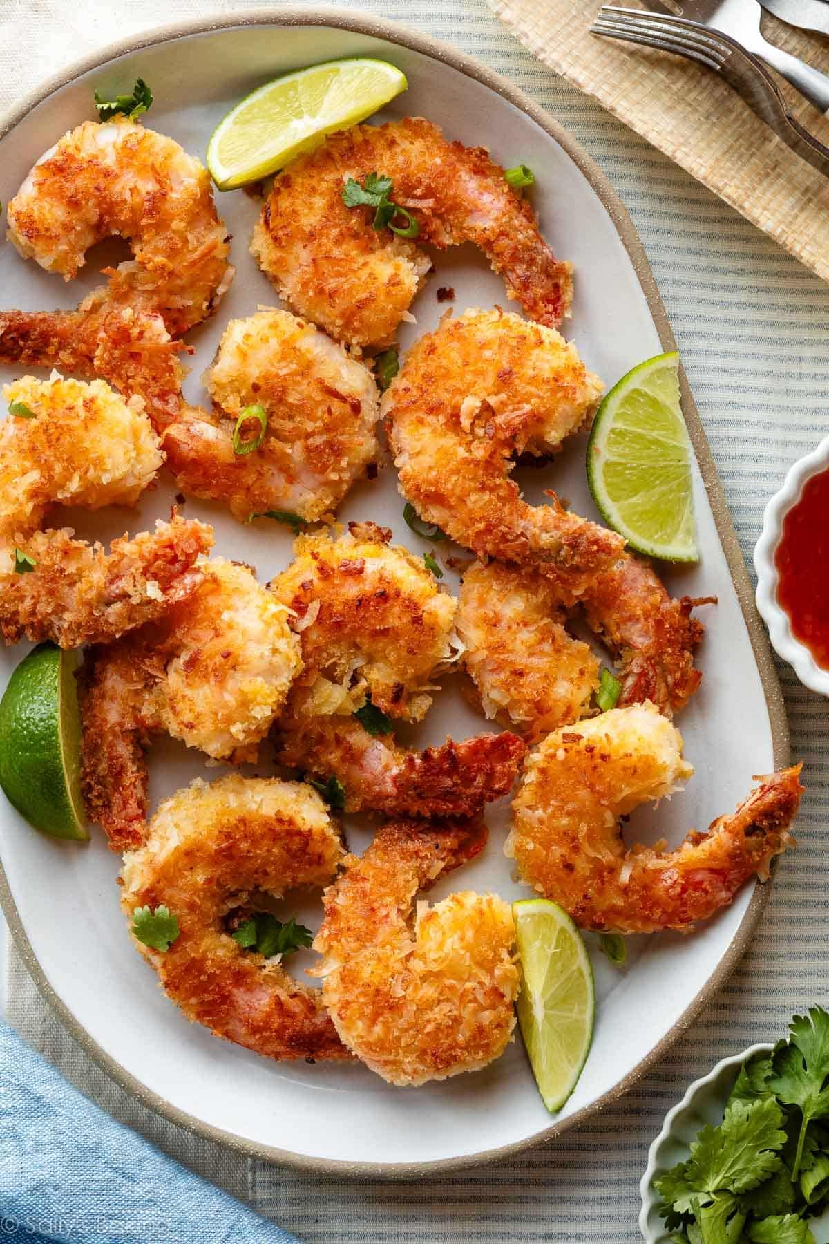 coconut shrimp on platter with lime wedges.