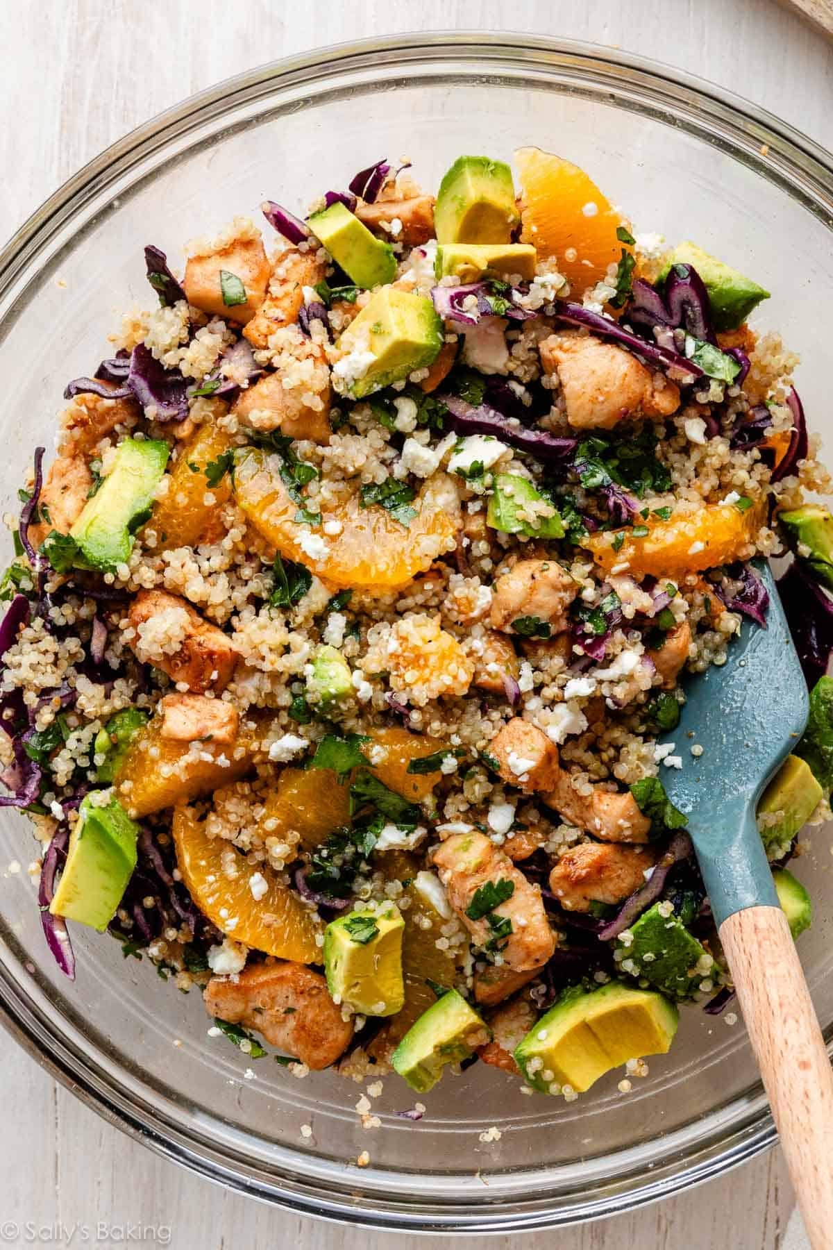 chicken, quinoa, oranges, and avocado in glass bowl.