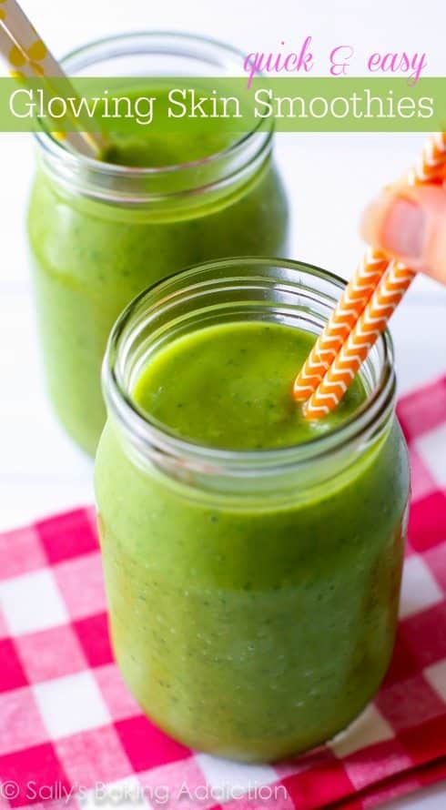 green smoothie in glasses with straws