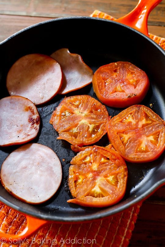 slices of Canadian bacon and tomatoes in a skillet