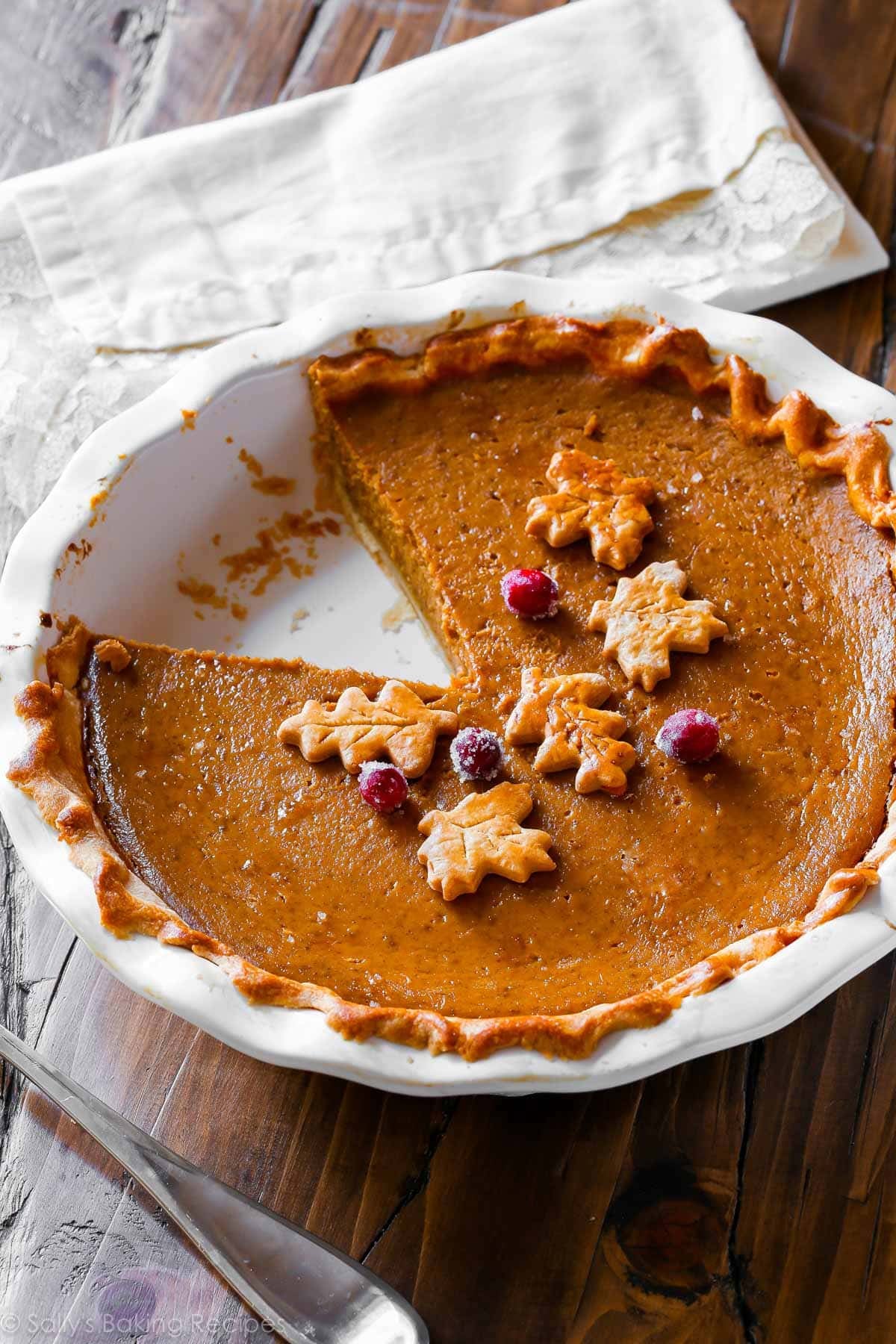 pumpkin pie with leaf shapes and sugared cranberries.