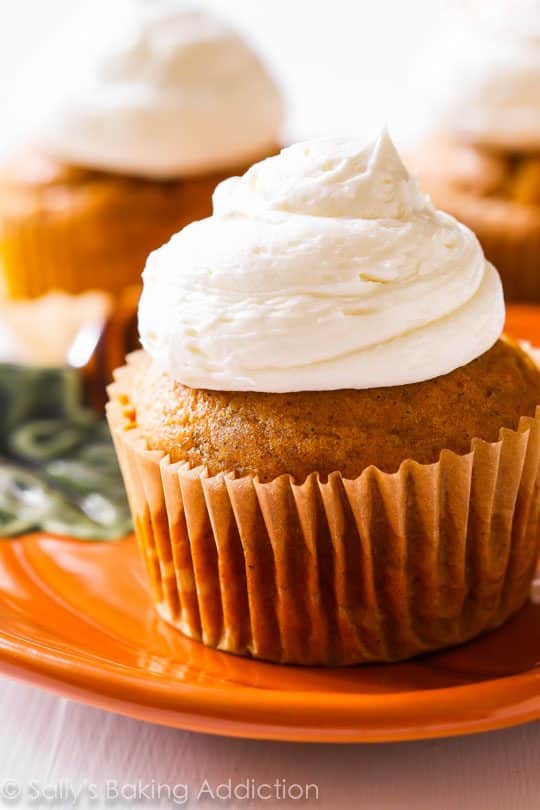 pumpkin cupcakes with marshmallow frosting on an orange plate