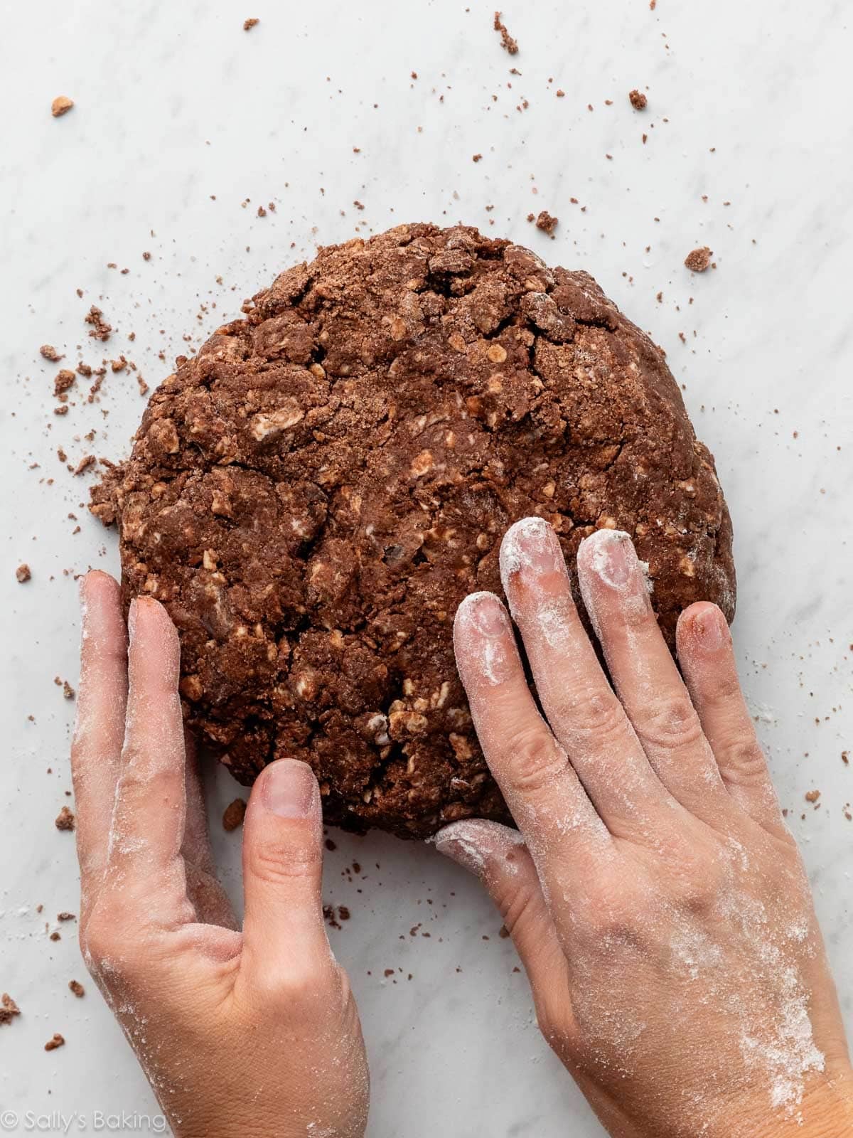 hands patting chocolate dough.