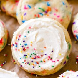 sugar cookies with sprinkles topped with vanilla frosting and sprinkles