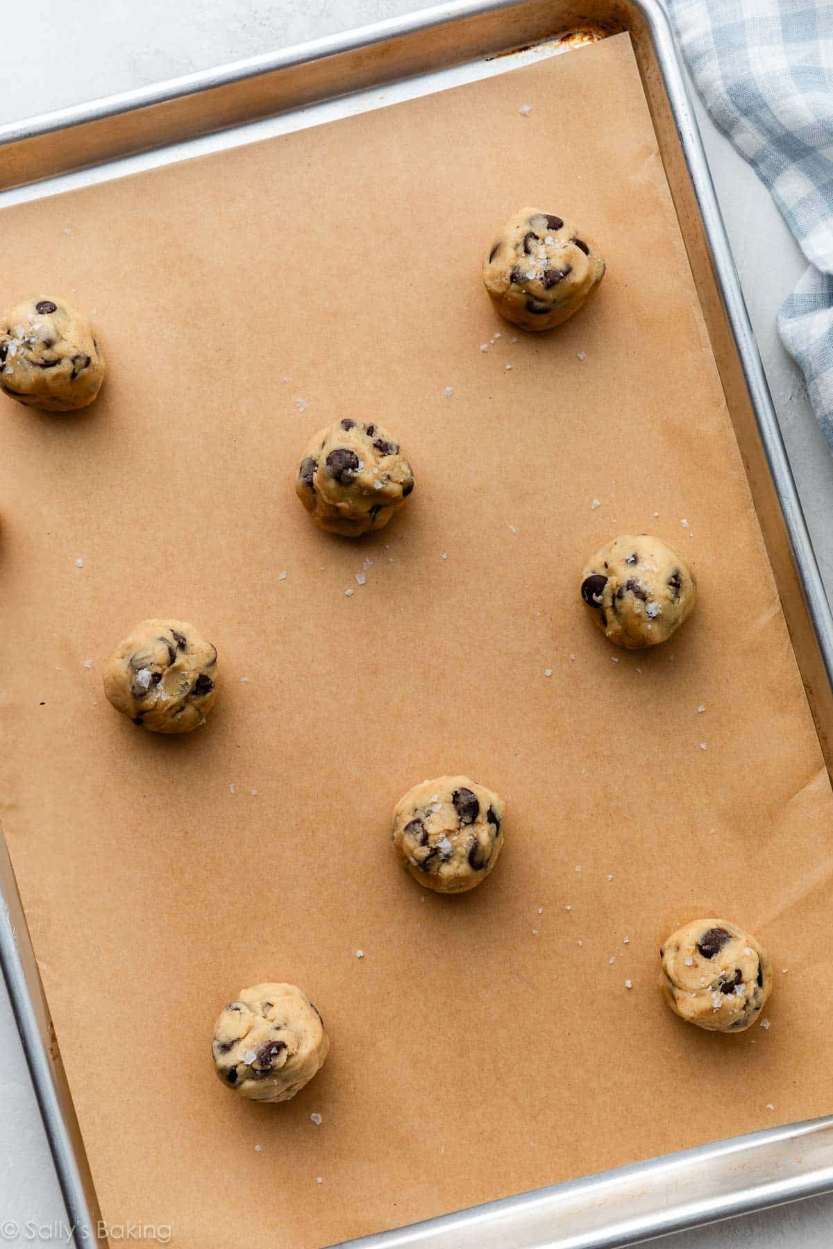 cookie dough balls on lined baking sheet.