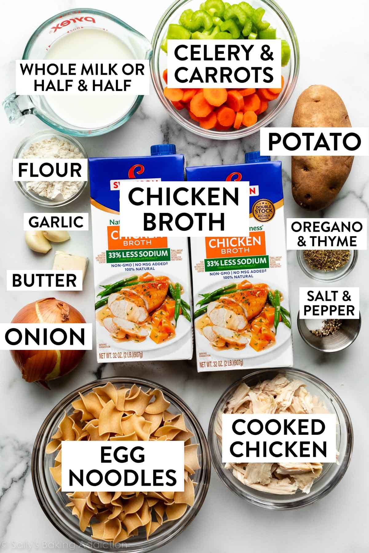 chicken broth, cooked chicken, noodles, carrots, celery, milk, and other ingredients on marble counter.