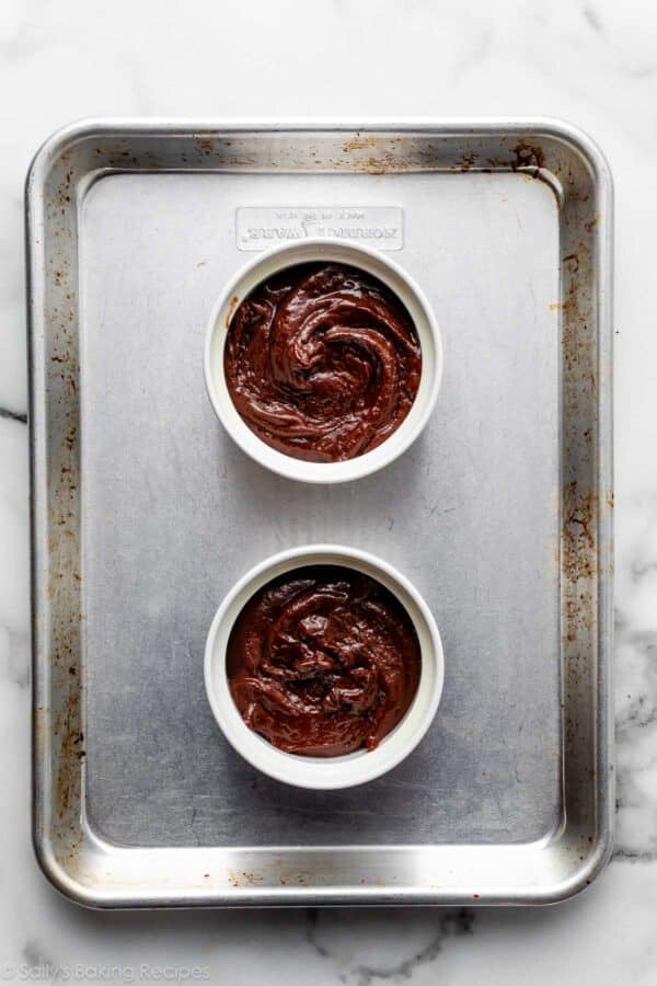 two ramekins of cake batter on small baking sheet.