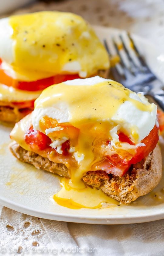 eggs benedict on a white plate with a fork