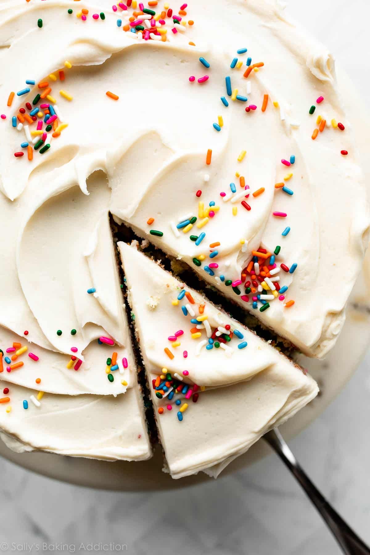 top of Funfetti sprinkle layer cake with slice being removed.
