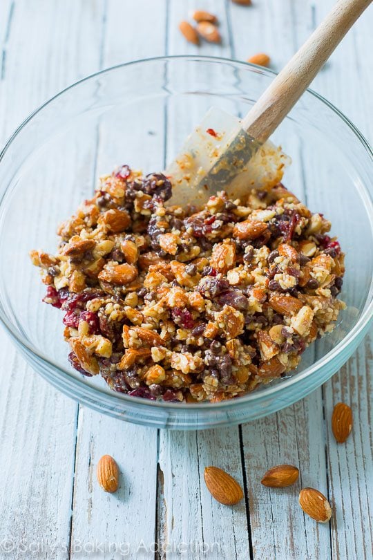 chocolate cherry almond snack bar mixture in a glass bowl with a spatula