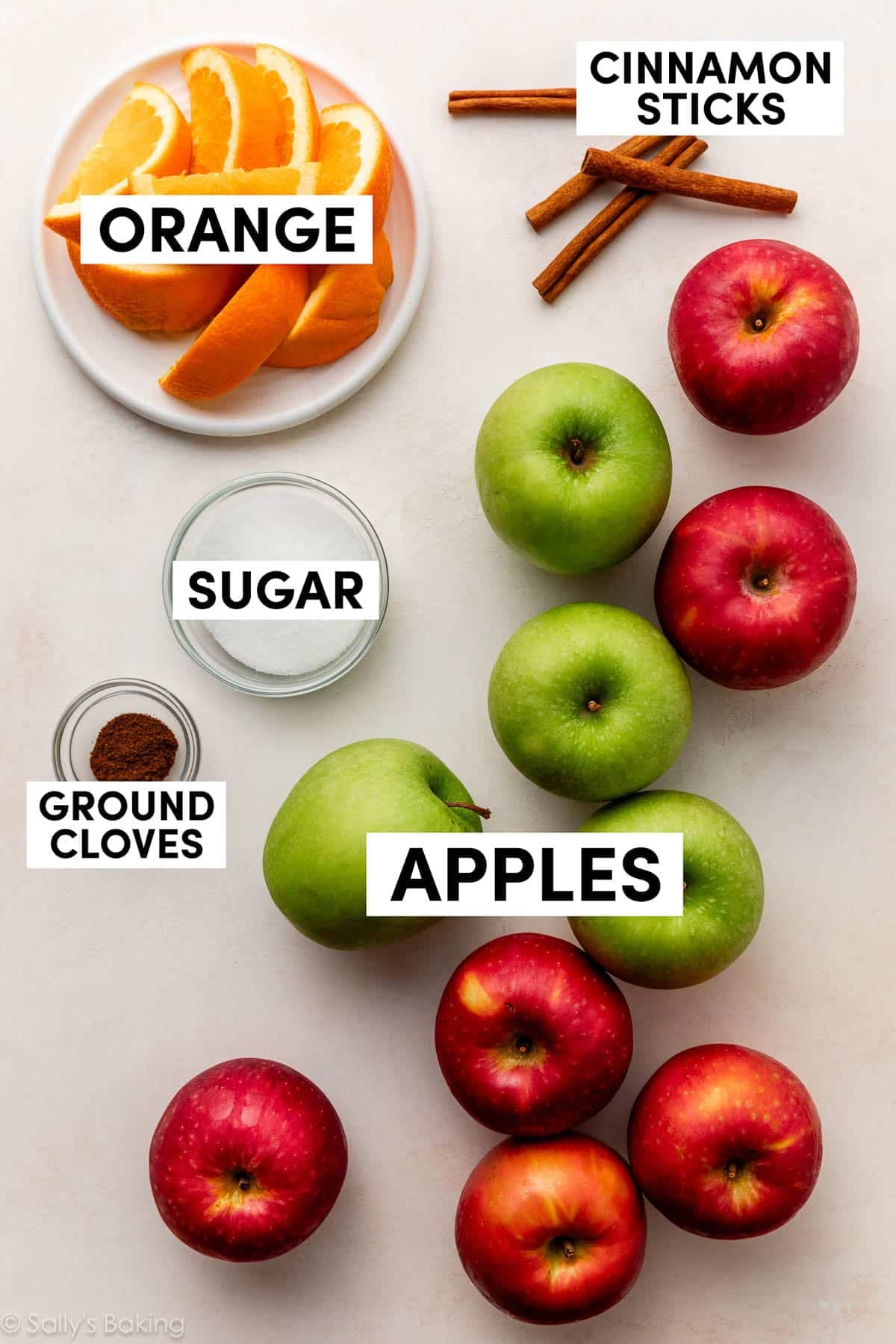 apples, sugar, orange slices, cinnamon sticks, and ground cloves.