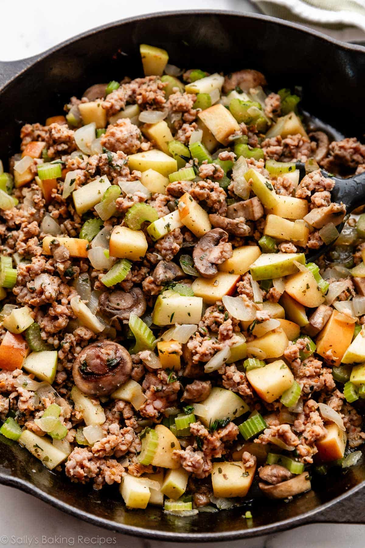 celery mushroom apple mixture in cast iron skillet.