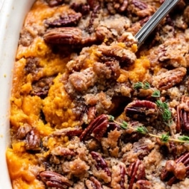dish of sweet potato casserole with a serving spoon.