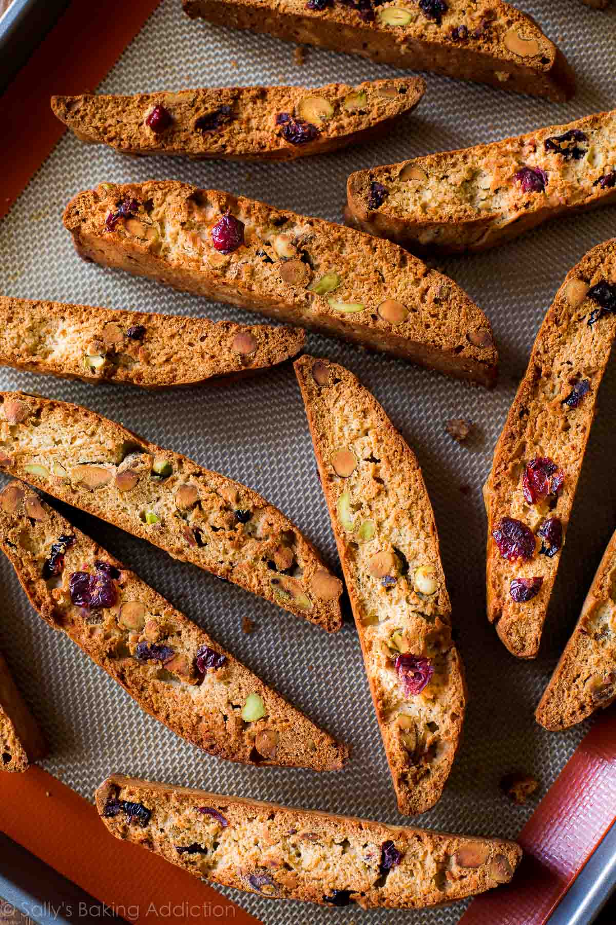 cranberry pistachio biscotti on a silpat baking mat on a baking sheet after baking