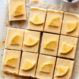 cut lemon Greek yogurt bars on parchment paper with lemon slices on each.