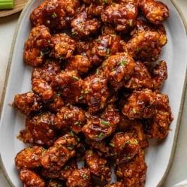platter of baked honey bbq chicken bites with fresh chives on top.