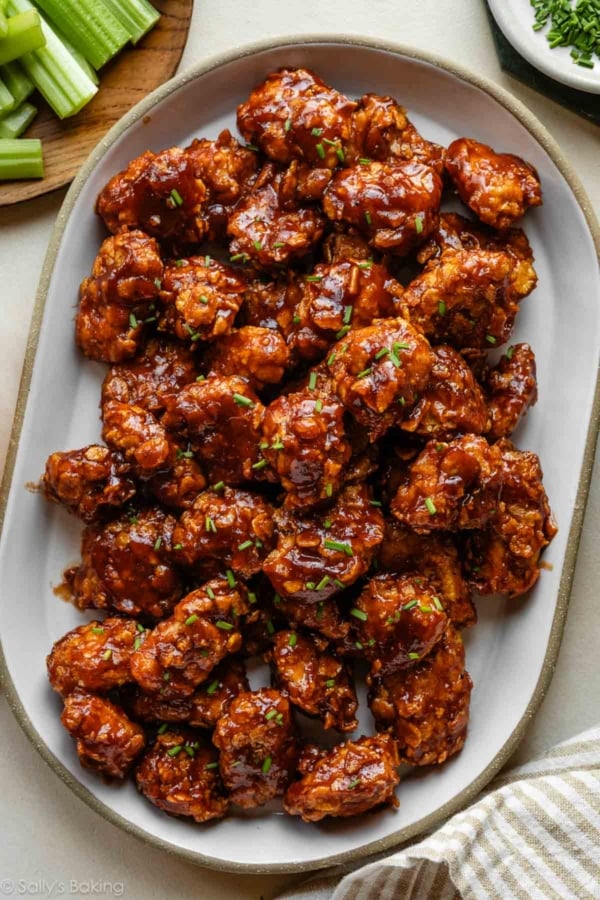 platter of baked honey bbq chicken bites with fresh chives on top.