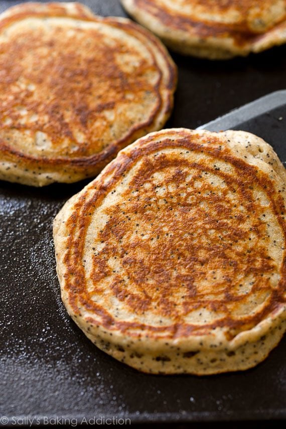 lemon poppy seed pancakes on a griddle