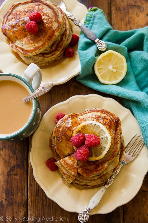 overhead image of stacks of lemon poppy seed pancakes with maple syrup on a cream plates