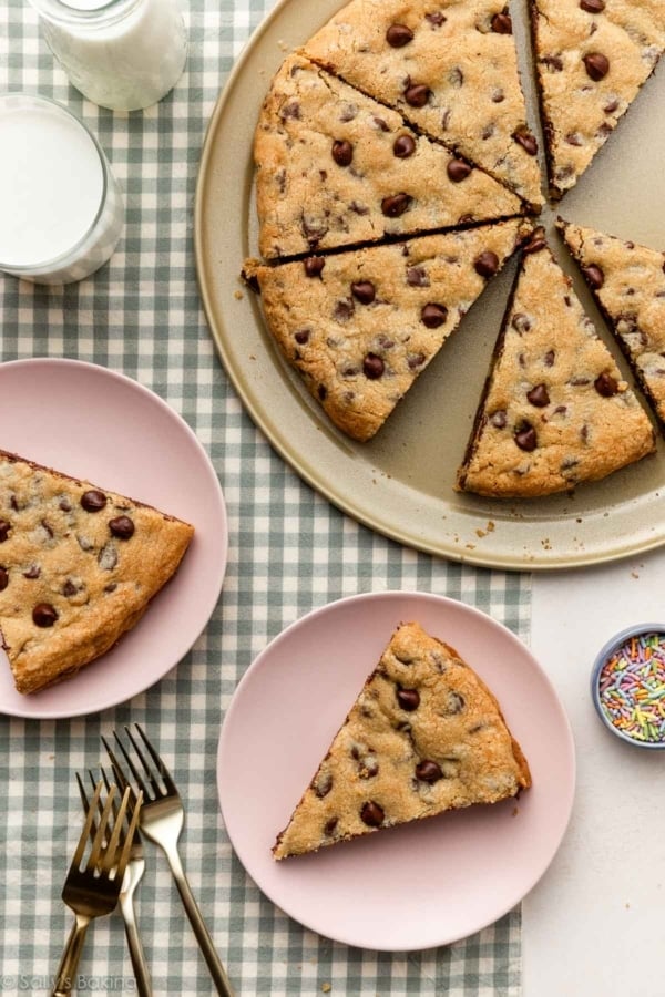 chocolate chip cookie pizza slices on pizza pan and plates.