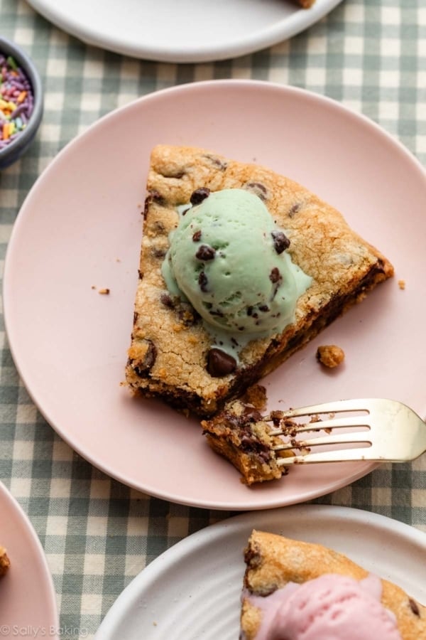 slice of chocolate chip cookie pizza with mint chocolate ice cream on top.