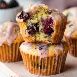 blackberry lemon poppy seed muffins with icing on top.