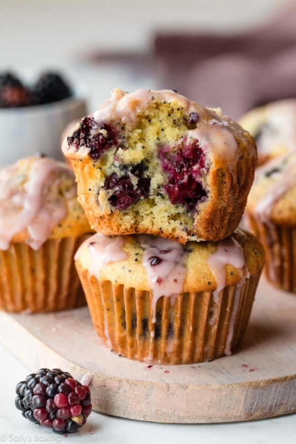 blackberry lemon poppy seed muffins with icing on top.