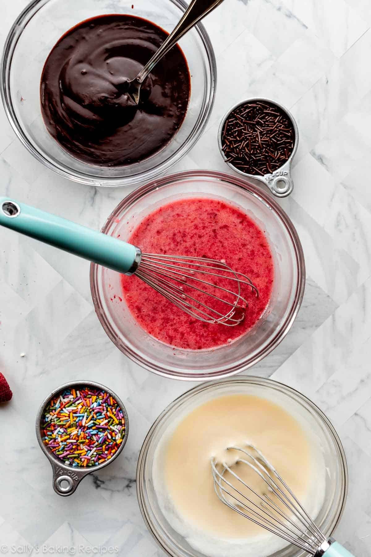 bowls of doughnut frostings including chocolate, strawberry, and vanilla.