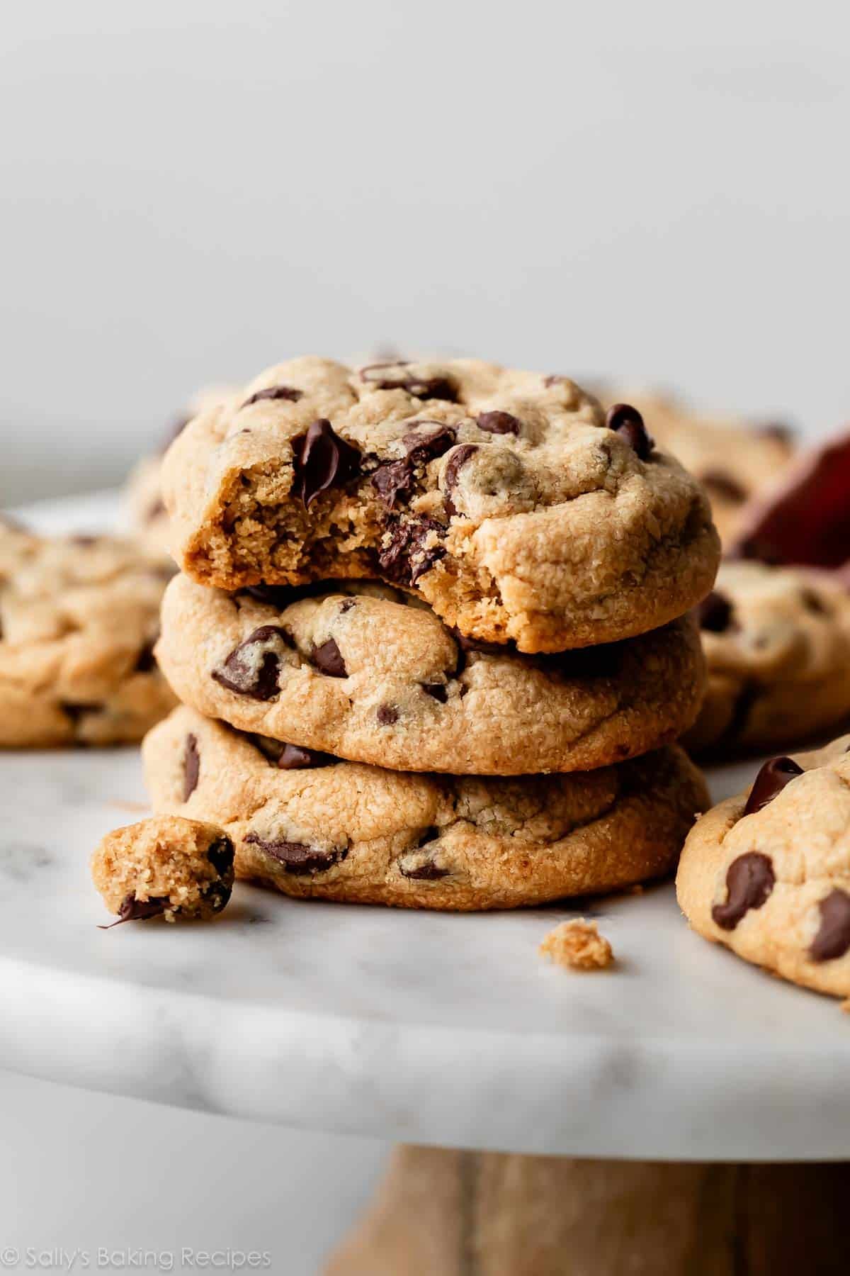 stack of peanut butter chocolate chip cookies on marble cake stand.