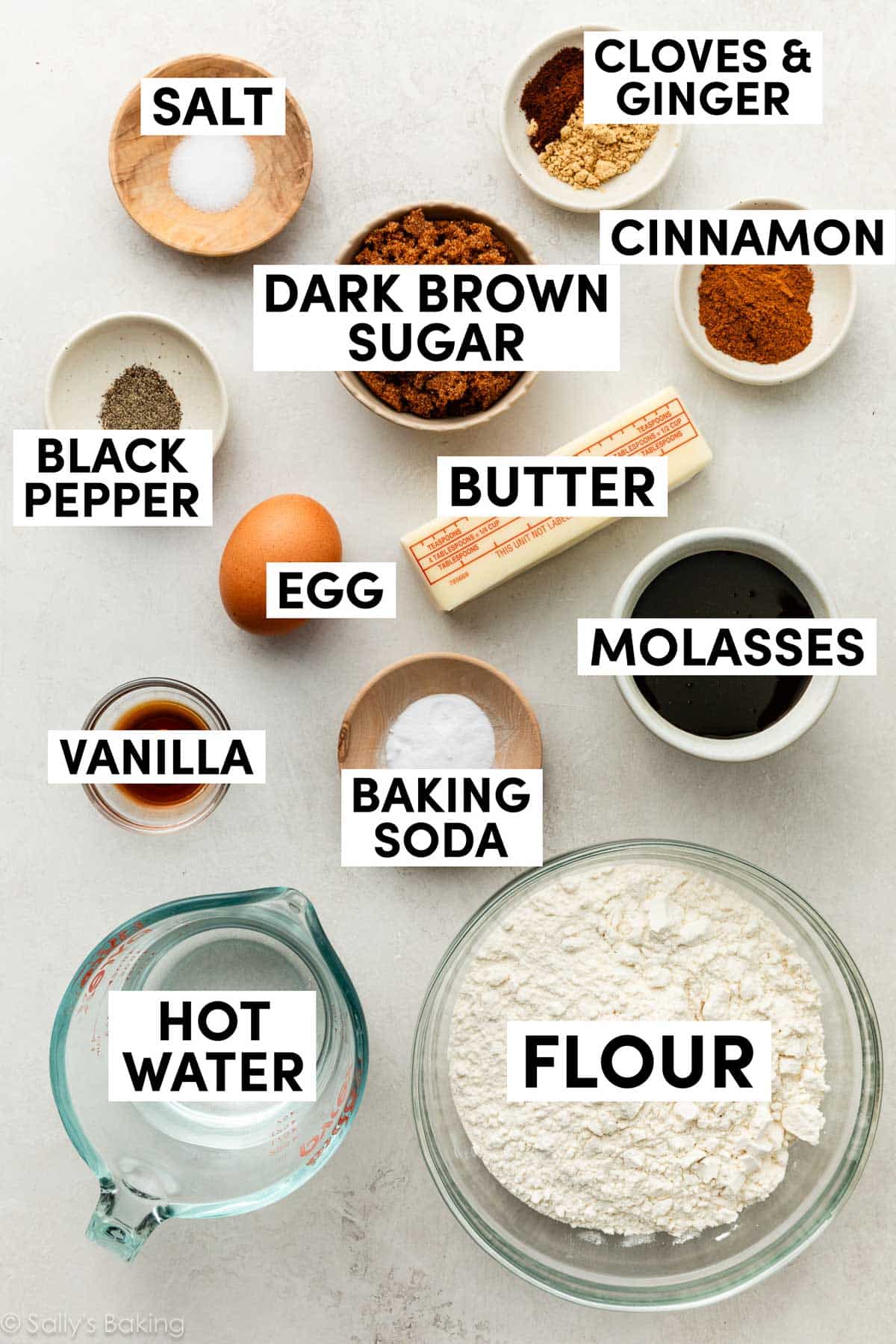 ingredients in bowls including flour, molasses, dark brown sugar, hot water, vanilla, and cinnamon.